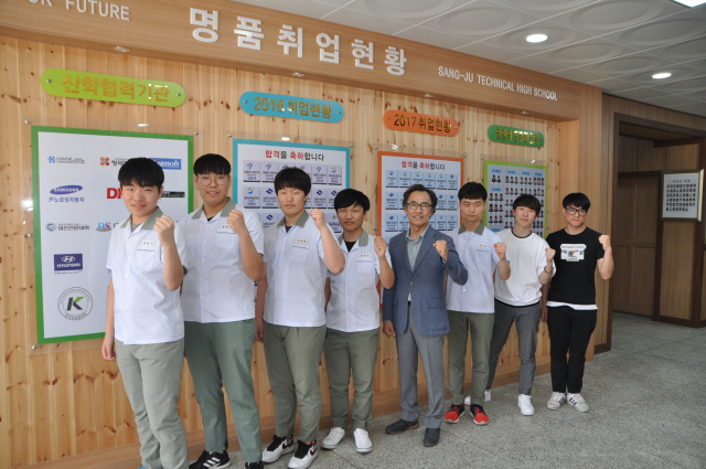 경북교육청공무원에 합격한 7명의 상주공고 학생들이 이철우교장과 교내에서 기념촬영을 하고 있다. 상주공고 제공
