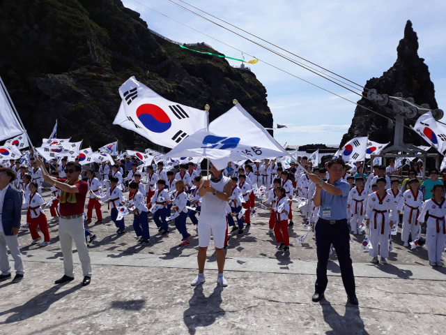광복절인 15일 오전 국기원 시범단과 대구·경북 태권도 시범단, 참관단 등 100여 명이 독도에서 태권도 공연을 선보이고 있다. 연합뉴스