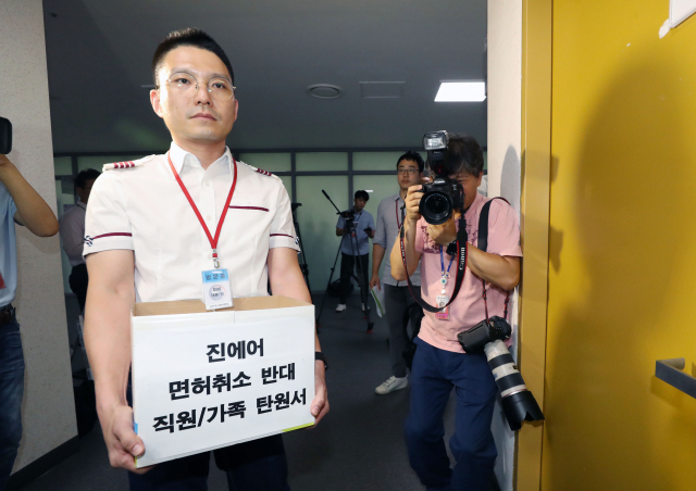 지난 8월 2일 오전 정부세종청사 국토교통부에서 진에어 면허 취소 검토 관련 이해관계자 의견청취 간담회가 열려 진에어 직원이 면허취소 반대 탄원서를 들고 회의장으로 향하고 있다. 연합뉴스