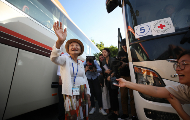 제21차 이산가족 상봉행사 1회차 첫날인 20일 오전 강원도 속초시 한화리조트에서 상봉 대상자들이 상봉장으로 출발하기 위해 버스로 향하며 취재진에게 손을 흔들고 있다. 2년 10개월 만에 열리는 이산가족 상봉은 20일부터 26일까지 금강산에서 진행된다. 연합뉴스