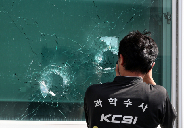 21일 70대 귀농인이 물 사용 문제로 마찰을 빚던 이웃에게 엽총을 쏜 뒤 봉화군 소천면사무소에 들어가 다시 엽총을 난사, 공무원 2명이 사망한 사고 현장에서 경찰이 창문을 관통한 엽총 흔적을 정밀 감식하고 있다.김영진 기자 kyjmaeil@msnet.co.kr