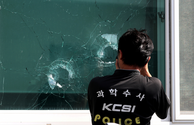 21일 70대 귀농인이 물 사용 문제로 마찰을 빚던 이웃에게 엽총을 쏜 뒤 봉화군 소천면사무소에 들어가 다시 엽총을 난사, 공무원 2명이 사망한 사고 현장에서 경찰이 엽총 흔적을 정밀 감식하고 있다. 김영진 기자 kyjmaeil@msnet.co.kr
