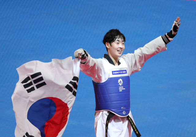 21일 인도네시아 자카르타 컨벤션센터 태권도장에서 열린 태권도 여자 67kg급 결승. 한국 이다빈이 카자흐스탄 칸셀 데니스를 꺾고 금메달을 획득한 뒤 태극기를 든 채 환하게 웃고 있다. 연합뉴스