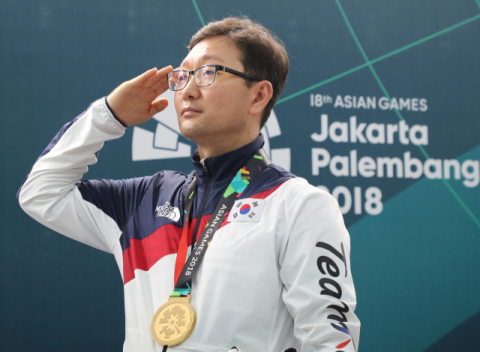 24일) 사격 남자 300미터 3자세 결선에서 금메달을 획득한 최영전이 애국가가 울리자 거수경례하고 있다. 연합뉴스