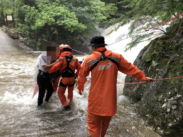 울산에 호우경보가 발효된 26일 오전 울산시 울주군 상북면 신불산의 한 계곡에서 폭우로 불어난 물 때문에 고립된 시민이 소방대에 의해 구조되고 있다. 연합뉴스