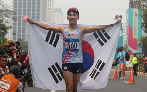 30일 인도네시아 자카르타 겔로라 붕 카르노(GBK) 외곽 경보 코스에서 열린 남자 50km 경보 결선에서 주현명이 동메달을 획득한 뒤 태극기를 들고 기뻐하고 있다. 연합뉴스