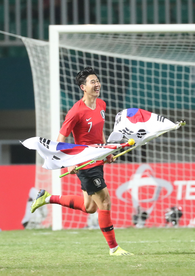1일 오후(현지시간) 인도네시아 자와바랏주 보고르 치비농의 파칸사리 스타디움에서 열린 2018 자카르타·팔렘방 아시안게임 남자축구 결승전 한국과 일본의 경기가 한국의 2대1 승리로 끝났다. 한국 손흥민이 경기 종료 휘슬이 울리자 태극기를 들고 그라운드를 누비고 있다. 연합뉴스