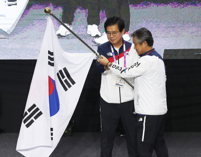 2일 오전(현지시간) 인도네시아 자카르타 코리아하우스에서 열린 2018 자카르타·팔렘방 아시안게임(AG) 선수단 해단식 및 기자회견에서 김성조 선수단장(왼쪽)이 이기흥 대한체육회장에게 단기를 반납하고 있다. 연합뉴스