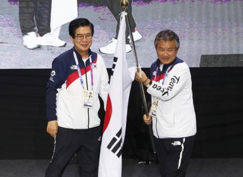 2일 인도네시아 자카르타 코리아하우스에서 열린 아시안게임 선수단 해단식 및 기자회견에서 김성조 선수단장(왼쪽)이 이기흥 대한체육회장에게 단기를 반납하고 있다. 연합뉴스