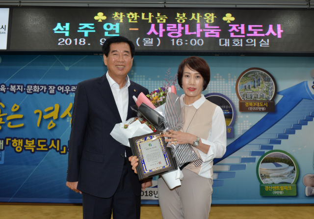 석주연(오른쪽)씨가 경산시 착한나눔 봉사왕으로 선정돼 최영조 시장으로부터 표창을 받았다.