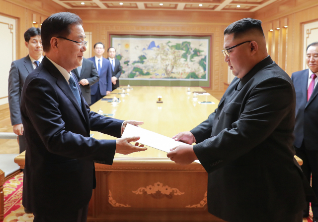 문재인 대통령의 특별 사절단 단장인 정의용 국가안보실장이 5일 북한 평양에서 김정은 북한 국무위원장을 만나 문 대통령의 친서를 전달하고 있다. 5인의 대북 특사단은 평양에 11시간 40분을 체류하며 남북정상회담 일정·남북관계 진전·비핵화 방안 협의를 마치고 오후 서울공항을 통해 귀환했다. 연합뉴스