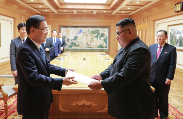 문재인 대통령의 특별 사절단 단장인 정의용 국가안보실장이 5일 북한 평양에서 김정은 북한 국무위원장을 만나 문 대통령의 친서를 전달하고 있다. 5인의 대북 특사단은 평양에 11시간 40분을 체류하며 남북정상회담 일정·남북관계 진전·비핵화 방안 협의를 마치고 오후 서울공항을 통해 귀환했다. 연합뉴스