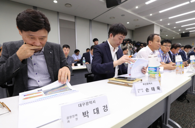 6일 오후 정부세종청사 국토교통부에서 열린 김해신공항 건설사업 타당성 평가 및 기본계획 수립 용역 중간보고회에서 박대경 대구광역시 공항정책과장(왼쪽)과 손태욱 부산광역시 공항기획팀장(왼쪽에서 두 번째)이 굳은 표정으로 자료를 보고 있다. 연합뉴스