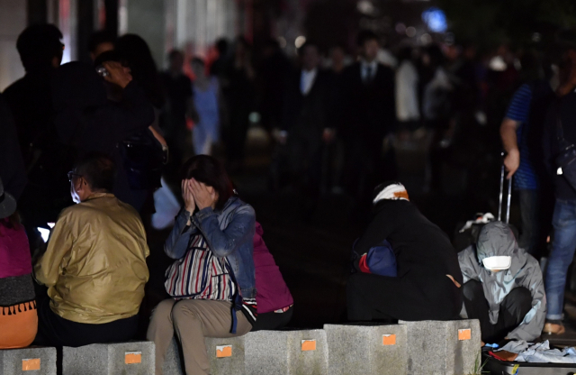 일본 북단 홋카이도 남쪽에서 6일 새벽 3시 8분께 규모 6.7의 지진이 발생했다. 사진은 이날 지진으로 정전이 발생한 삿포로 시내에서 시민들이 피곤한 모습으로 길가에 앉아 있는 모습. 연합뉴스