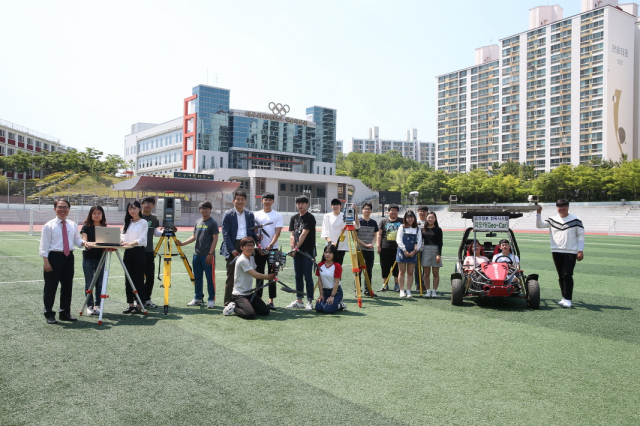 대구과학대학교 측지정보과 교수와 학생들이 대운동장에서 단체 촬영을 하고 있다.