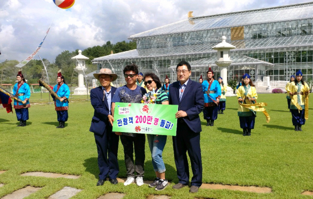 주낙영(오른쪽) 경주시장이 부산에 사는 김형관 씨 부부에게 동궁원 개장 200만 번째 입장객 행운권을 전달하고 있다.