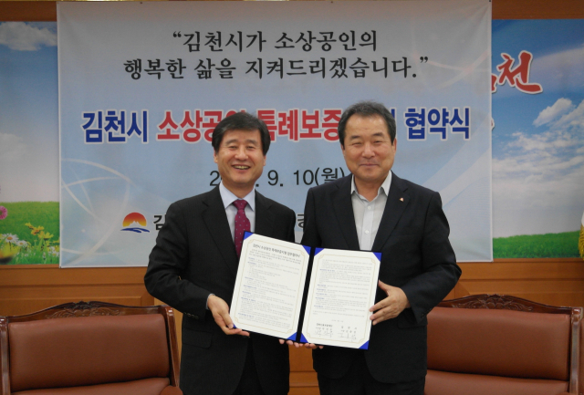 박진우 경북신용보증재단 이사장(왼쪽)과 김충섭 김천시장이 김천지역 소상공인 금융지원 특별보증 협약을 체결하고 있다. 경북신용보증재단 제공