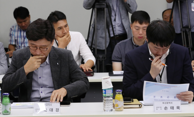 6일 오후 정부세종청사 국토교통부에서 열린 김해신공항 건설사업 타당성 평가 및 기본계획 수립 용역 중간보고회에서 박대경 대구광역시 공항정책과장(왼쪽)과 손태욱 부산광역시 공항기획팀장이 굳은 표정으로 자료를 보고 있다. 연합뉴스
