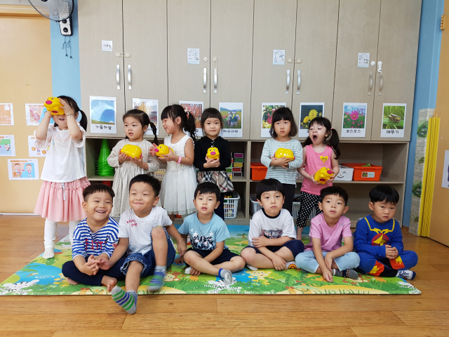 꿈꾸는 저금통을 받아든 어린이들이 저금통을 들어보이고 있다. 휴천 1동사무소 제공