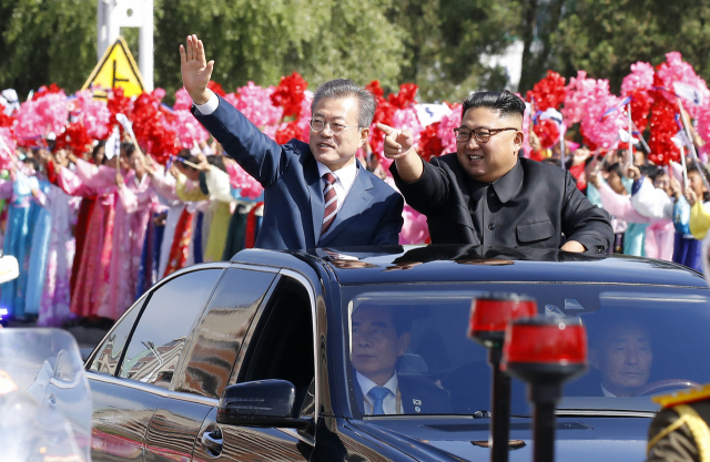 문재인 대통령과 김정은 국무위원장이 무개차를 타고 18일 평양순안공항에서 백화원 초대소로 이동하며 시민들을 향해 인사하고 있다. 평양사진공동취재단