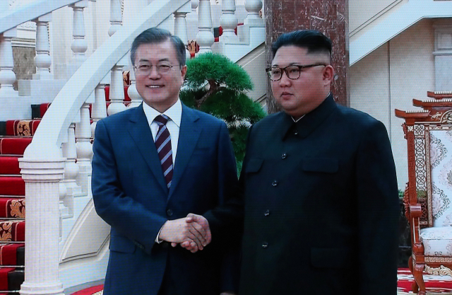 문재인 대통령과 김정은 북한 국무위원장이 18일 평양 조선노동당 중앙위원회 본부청사에서 가진 1차 정상회담에서 악수하는 장면이 서울 DDP 프레스센터에 중계되고 있다. 노동당사에서의 남북 정상회담은 이번이 처음이다. 연합뉴스