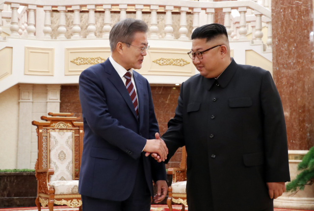 문재인 대통령이 18일 오후 평양 조선노동당 중앙위원회 본부 청사 로비에서 김정은 북한 국무위원장과 정상회담 시작에 전 악수를 하고 있다. 연합뉴스
