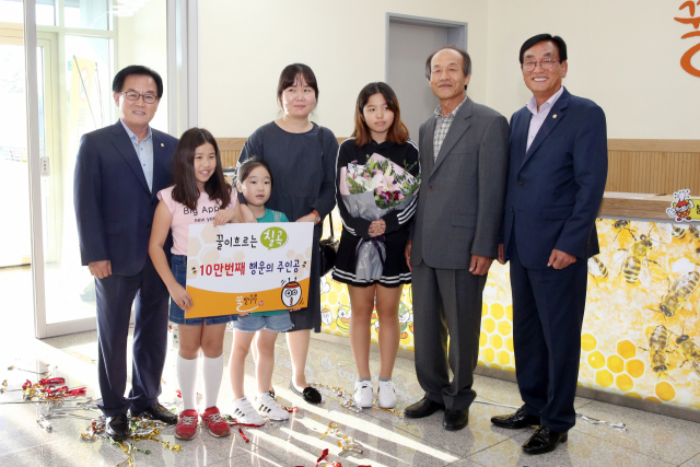 꿀벌나라테마공원의 10만 번째 관람객인 곽윤정(왼쪽 네번 째)씨 가족이 백선기 칠곡군수와 이재오 군의회 의장 등과 기념사진을 찍고 있다. 칠곡군 제공