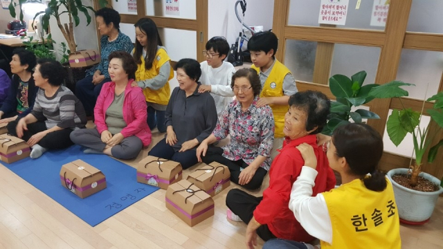 대구한솔초교 학생들이 학교 인근 2곳의 아파트 노인정 웃어른들에게 어깨 주물러주기 등 봉사활동을 하고 있다. 대구한솔초교 제공