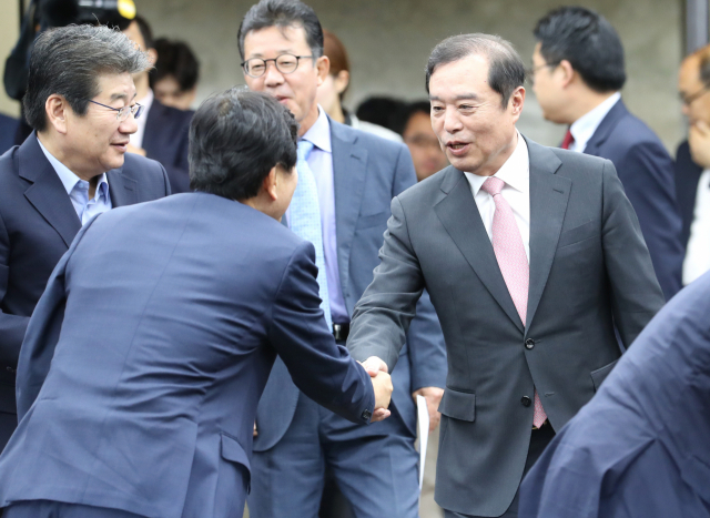 자유한국당 김병준 비상대책위원장(오른쪽)이 27일 오전 국회에서 열린 긴급 의원총회에 참석하며 의원들과 인사하고 있다. 연합뉴스