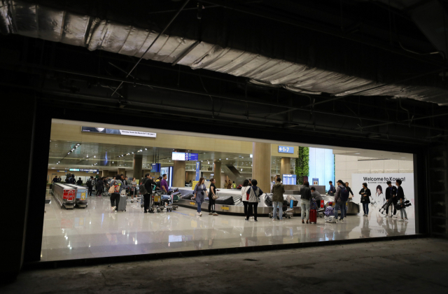정부가 입국장 면세점을 내년 인천공항에 설치하겠다고 발표한 27일 이용객들이 인천공항 제1터미널 입국장 면세점 예정 공간 앞을 지나고 있다. 연합뉴스