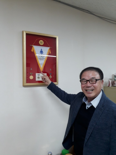 최경용 경북육상연맹회장이 몽골올림픽위원회에서 받은 훈장을 설명하고 있다. 이상헌 기자