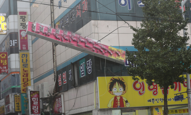 6일 오전 제25호 태풍 콩레이의 영향권에 든 전남 여수시 여서동 인근 한 상가에서 강풍을 이기지 못한 간판이 떨어진 채로 매달려 있다. 연합뉴스