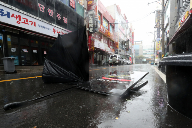제25호 태풍 콩레이가 남해안으로 접근한 6일 오전 전남 여수시 학동 거리에 강풍으로 입간판이 넘어지고 우산이 나뒹굴고 있다. 연합뉴스