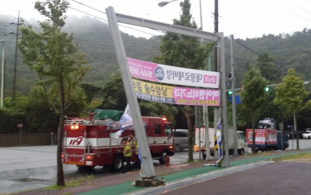 제25호 태풍 콩레이가 접근한 6일 오전 광주 북구 각화동 거리에 설치된 펼침막 거치대가 강풍으로 기울어져 소방대원이 안전조처를 하고 있다. 연합뉴스