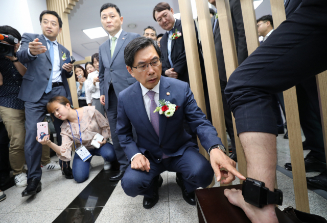 박상기 법무부 장관이 6일 동대문구 서울보호관찰소에서 열린 전자감독제도 시행 10주년 기념행사에서 전자발찌를 살펴보고 있다. 정부는 기존 전자발찌의 단점을 보완한 일체형 전자발찌를 이달부터 순차적으로 사용한다. 일체형 전자발찌는 부착장치와 휴대용 위치추적장치를 하나로 묶은 형태다. 연합뉴스