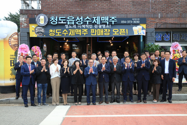 청도 복숭아와 반시로 만든 수제맥주를 판매하는 청도맥주 판매장이 8일 문을 열었다. 개장식 참가자들이 기념촬영을 하는 모습. 청도군 제공