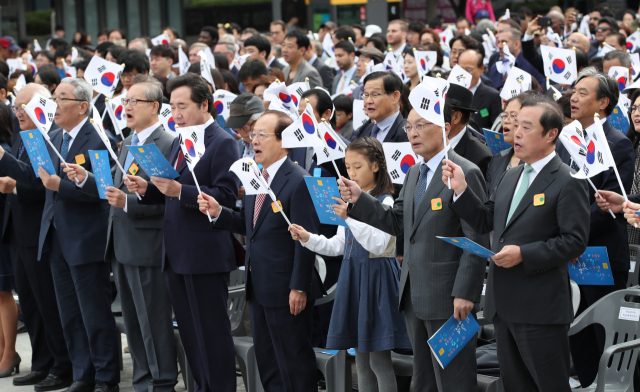 9일 서울 종로구 광화문 광장 세종대왕 동상 앞에서 열린 제572돌 한글날 경축식에서 이낙연 국무총리, 더불어민주당 이해찬 대표, 자유한국당 김병준 비상대책위원장, 바른미래당 손학규 대표, 정의당 윤소하 원내대표 등 참석자들이 한글날 노래를 부르며 태극기를 흔들고 있다. 연합뉴스