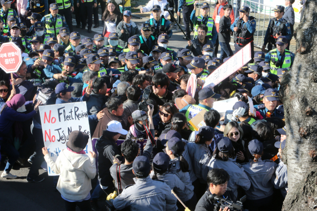 11일 제주 서귀포시 강정마을 평화센터 주변 사거리에서 해군 국제관함식 반대 주민과 시민사회단체 활동가들이 경찰에 둘러싸여 시위를 벌이고 있다. 연합뉴스