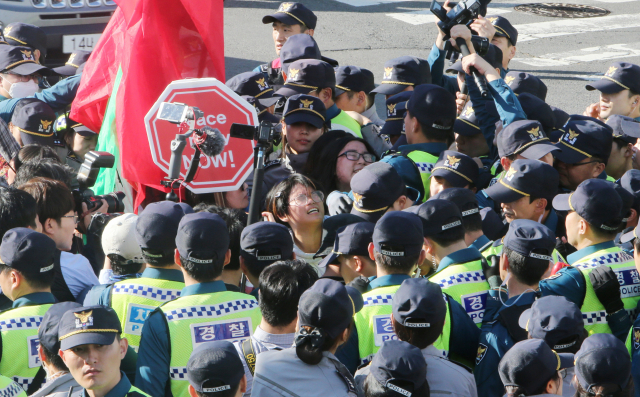 11일 제주 서귀포시 강정마을 평화센터 주변 사거리에서 해군 국제관함식 반대 주민과 시민사회단체 활동가들이 경찰에 둘러싸여 시위를 벌이고 있다. 연합뉴스