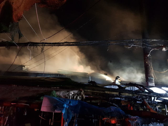 12일 오전 4시께 대구시 중구 태평로 번개시장 안 점포 위에서 소방대원이 불을 끄고 있다. 연합뉴스