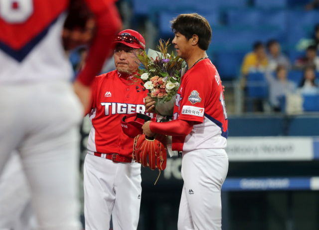 18일 대구삼성라이온즈파크에서 열린 프로야구 KIA 타이거즈와 삼성 라이온즈의 경기. 1회말 수비를 마친 KIA 임창용이 김기태 감독에게 꽃다발을 받고 있다. 임창용은 이날 선발 출장해 한·미·일 프로야구 통산 1천 경기 출장 대기록 달성했다. 연합뉴스