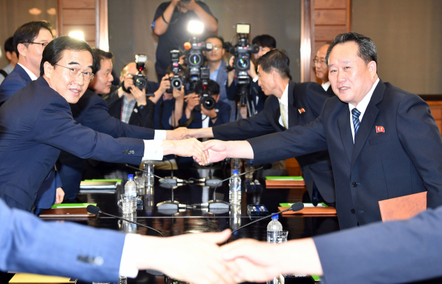 지난 8월 판문점 북측 통일각에서 열린 남북고위급회담에서 우리측 수석대표 조명균 통일부 장관(왼쪽)과 북측 수석대표 리선권 조국평화통일위원회 위원장이 회담을 마치고 악수하고 있다. 연합뉴스