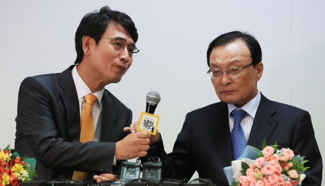 노무현재단 후임 이사장인 유시민 전 보건복지부 장관(왼쪽)이 15일 오전 서울 마포구 노무현재단 사무실에서 열린 이사장 이·취임식에서 더불어민주당 이해찬 대표에게 마이크를 건네고 있다. 연합뉴스