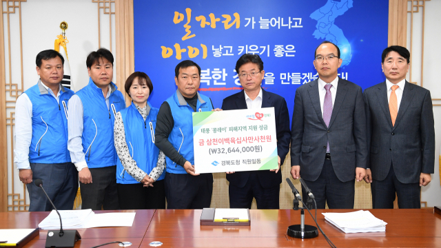 경북도청 공무원들이 태풍 콩레이 피해 이재민을 돕기 위해 모금한 3천200여만원을 이철우 경북도지사에게 전달하며 기념사진을 찍고 있다. 경북도 제공