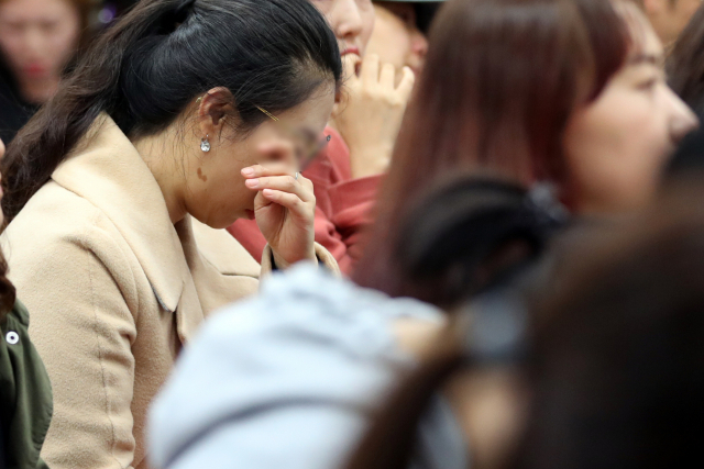교비를 숙박업소, 성인용품점에서 쓰거나 아파트 관리비와 노래방비용 등으로 내는 등 약 7억원을 부당하게 사용한 것으로 조사된 동탄 환희유치원의 전 원장 A씨와 운영에 참여한 두 아들이 17일 오후 경기도 화성시 동탄 환희유치원 강당에서 학부모들 앞에 서자 한 학부모가 눈물을 흘리고 있다. A씨는 지난해 7월 교육청으로부터 파면 조치를 받았지만 이후 총괄부장으로 지내며 원장을 공석으로 두고 사실살 유치원을 운영해온 것으로 밝혀졌다. 연합뉴스