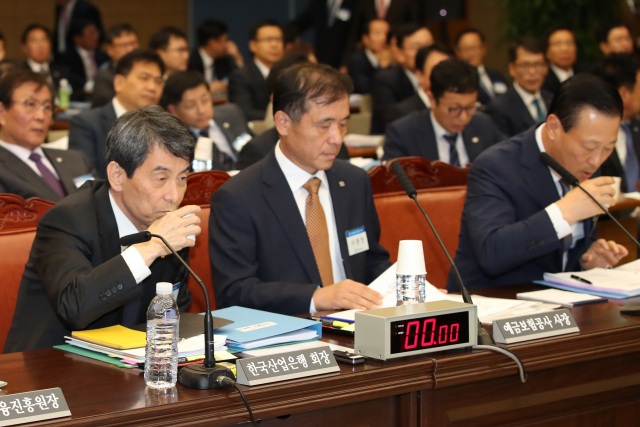 이동걸 KDB산업은행 회장(왼쪽)이 22일 서울 중구 을지로 IBK기업은행에서 열린 국회 정무위원회의 예금보험공사, 한국산업은행, 중소기업은행, 서민금융진흥원 등에 대한 국정감사에서 물을 마시고 있다. 오른쪽 김도진 IBK기업은행 행장. 연합뉴스