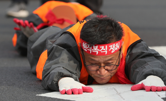 전국공무원노조 조합원들이 22일 오후 서울 종로구 광화문 앞에서 해직자 원직복직을 촉구하며 오체투지를 하고 있다. 연합뉴스
