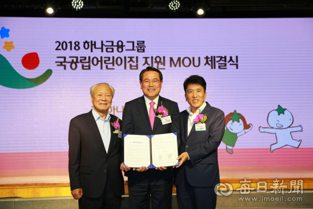 하나금융그룹 KEB국민은행 함영주 은행장(오른쪽)과 전찬걸 울진군수(가운데)가 울진군 북면에 국공립어린이집 지원을 위한 업무협약을 나누고 있다. 울진군 제공