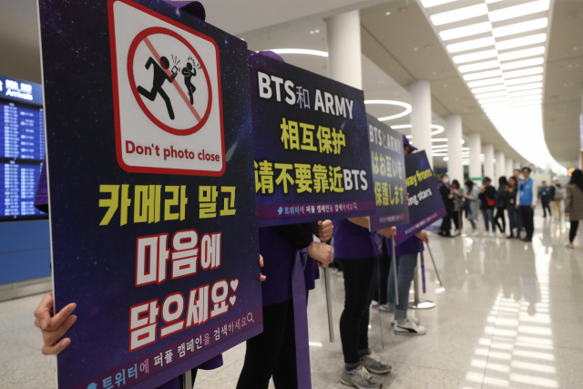 24일 오전 인천공항에서 월드투어를 마치고 귀국하는 방탄소년단을 보기 위해 입국장을 찾은 일부 팬들이 질서 유지를 위한 