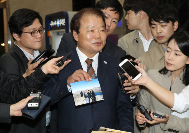지난달 평양에서 열린 제3차 남북정상회담 당시 특별수행원으로 참여했던 신한용 개성공단기업협회 회장이 23일 오후 서울 광화문 한 식당에서 열린 특별수행원 만찬에 참석하기 위해 식당으로 들어서며 당시 사진을 보여주고 있다. 연합뉴스